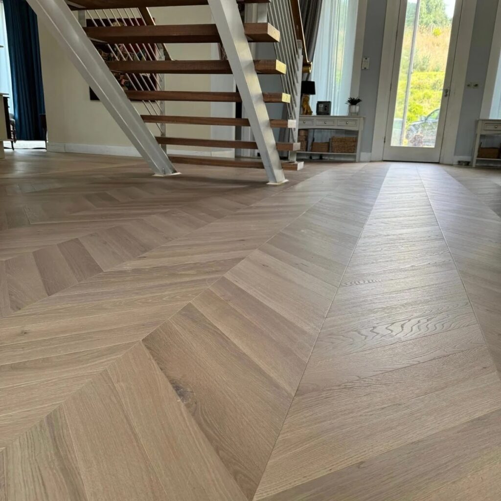 Light oak chevron wooden flooring by a staircase